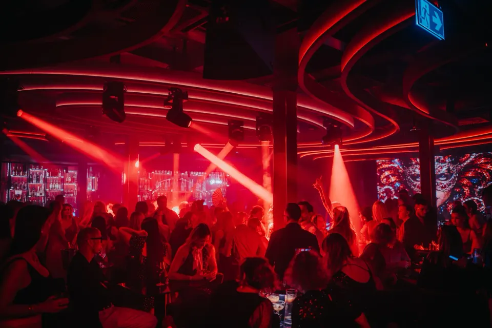 Sala klubu SiSi pełna gości w czerwonym świetle reflektorów