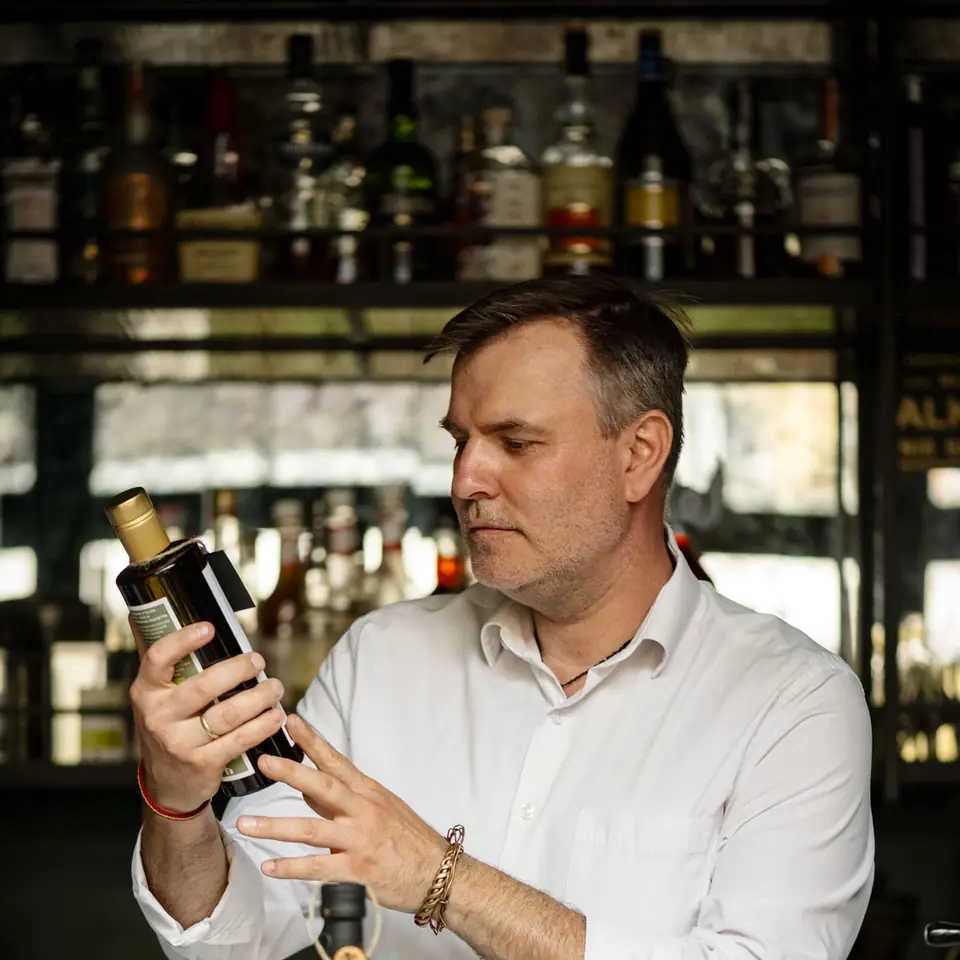 Paweł Anders, gospodarz The Cork, z butelką oliwy przy barze